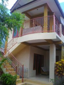 a balcony of a house with a staircase at Pondok Sunrise 2 in Gili Trawangan