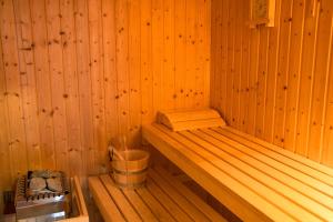 a sauna with a bench and a bucket in it at Saint Catherine Hotel in Pythagoreio