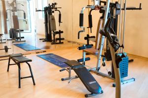 a gym with several tread machines and a mirror at Saint Catherine Hotel in Pythagoreio