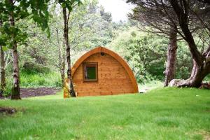 a small wooden building in the middle of a field at Dunvegan Camping Pods in Dunvegan