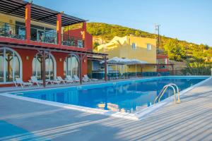a hotel with a swimming pool in front of a building at Saint Catherine Hotel in Pythagoreio