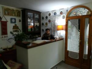 a man sitting at a counter in a room at B&B Il Ghiro in Pracchia
