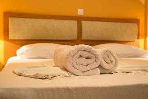 a pile of towels sitting on top of a bed at Saint Catherine Hotel in Pythagoreio