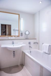 a bathroom with a sink and a tub and a mirror at The River Lee Hotel a member of The Doyle Collection in Cork