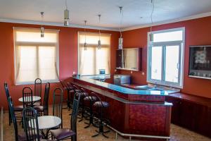 a bar in a restaurant with chairs and tables at Saint Catherine Hotel in Pythagoreio