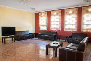 a living room with leather furniture and a flat screen tv at Saint Catherine Hotel in Pythagoreio