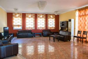 a large living room with leather furniture and windows at Saint Catherine Hotel in Pythagoreio