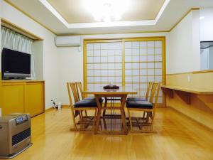 uma sala de jantar com mesa e cadeiras em Utatei Villa em Takayama