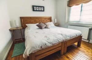 1 dormitorio con 1 cama grande y cabecero de madera en Innata Casa Hostal en Punta Arenas