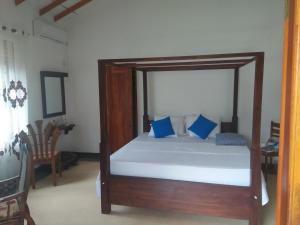 a bedroom with a wooden bed with blue pillows at Jungle view one bedroom apartment in Unawatuna