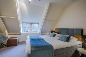 a bedroom with a large bed with a large window at Landgoed De Uitkijk Hellendoorn in Hellendoorn