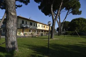 a building with trees and a playground in the grass at Agriturismo Redipuglia in Alberese