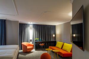 Habitación de hotel con cama y sofá en The Midtown Hotel en Colonia