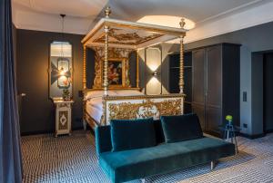 ケルンにあるThe Midtown Hotelのベッドルーム(青いソファ、天蓋付きベッド付)