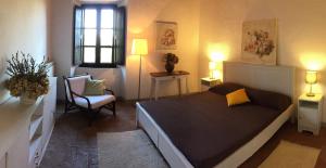 ein Schlafzimmer mit einem Bett, einem Stuhl und einem Fenster in der Unterkunft Agriturismo Montecalvo in Ischia di Castro