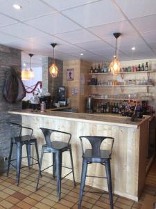 a bar in a restaurant with four stools at Hotel Plein Soleil in Allos