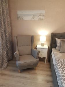 a bedroom with a chair and a bed and a lamp at 2 Bedroom Lux Apartments in Rīga