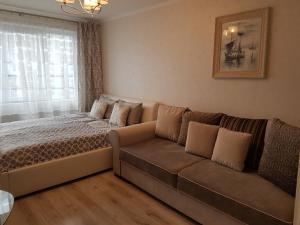 2 Bedroom Lux Apartments في ريغا: غرفة نوم مع أريكة وسرير ونافذة