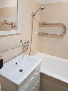 a bathroom with a white sink and a bath tub at 2 Bedroom Lux Apartments in Rīga +27 photos