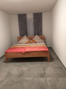 a bedroom with a large bed with red sheets and pillows at Casa Friedolin in Friedrichshafen