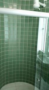 a green tiled bathroom with a glass shower at POUSADA CAJÁ in Flores