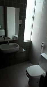 a bathroom with a toilet and a sink and a mirror at POUSADA CAJÁ in Flores