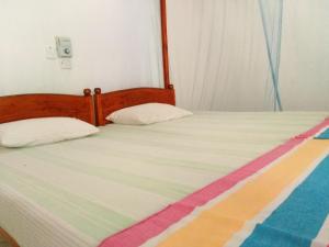 a bedroom with two beds with a colorful blanket at Sunnys Beach Guest House in Hikkaduwa
