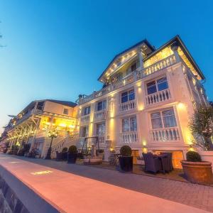 ein großes weißes Gebäude mit Lichtern an einer Straße in der Unterkunft Hotel Peter Schaefer in Ginsheim-Gustavsburg