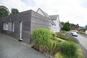 una pequeña casa con fachada de madera en una calle en Refugium-Luebeck en Lübeck