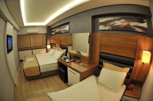 a small room with a bed and a desk at İzmir Otel Kabaçam in İzmir