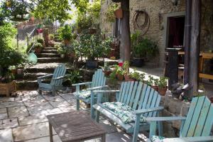 three blue chairs and a table in a garden at La Balconata in Bagni di Lucca