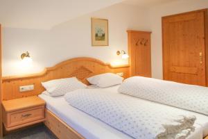 a bedroom with two beds and a wooden headboard at Apartments- und Ferienhaus Anton in Garmisch-Partenkirchen