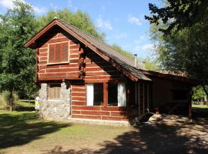 uma pequena cabana de madeira com uma janela e um telhado em Cabañas Los Maderos em Villa General Belgrano