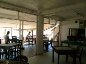 a restaurant with tables and chairs and people sitting at tables at Sunnys Beach Guest House in Hikkaduwa +15 photos