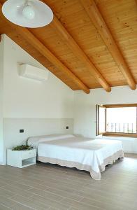 a bedroom with a large bed and a wooden ceiling at Al Vajo Dependance - Apartments-Zimmer in Lazise