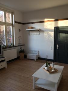 een woonkamer met een witte tafel en een zwarte deur bij FeWo Gut Ohlhof in Goslar