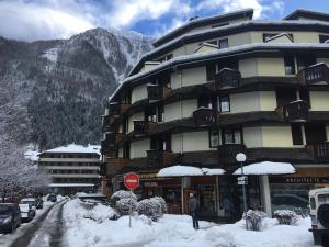 Un gran edificio con nieve frente a una montaña. en Art Studio, en Chamonix-Mont-Blanc