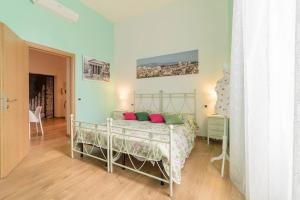 um quarto com uma cama com almofadas verdes e cor-de-rosa em Accogliente Appartamento al Colosseo em Roma