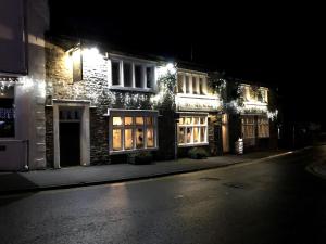 a lit up building on a street at night at The Royal Oak in Settle