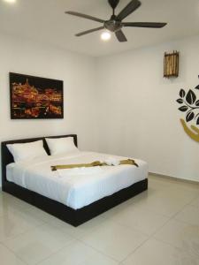 a bedroom with a bed with a ceiling fan at Art Villa in Alor Setar