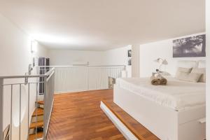 a white bedroom with a bed and a staircase at Alessia's Flat- Portello 2 in Milan