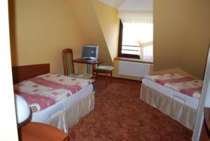 a hotel room with two beds and a television at Hotel Anka in Słubice