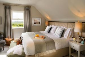 a bedroom with a large bed with a tray of food on it at The Hawthorn in Doolin