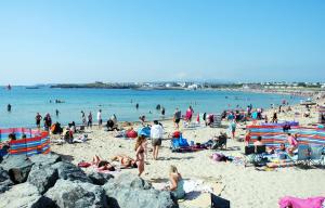 a large group of people on a beach at The Beach Motel in Trearddur