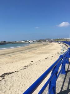 a blue fence on a beach next to the water at The Beach Motel in Trearddur