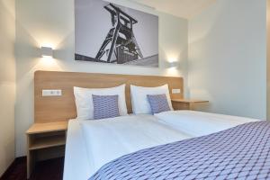 Un pat sau paturi într-o cameră la McDreams Hotel Essen +14 fotografii