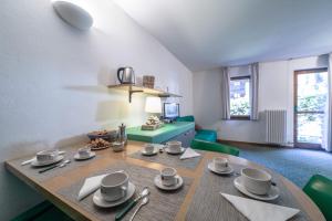 a dining room with a table and a living room at Residence Apfel in Gressoney-Saint-Jean