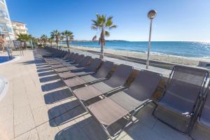 a row of chaise lounge chairs on the beach at Apartamentos Turísticos Augustus in Cambrils