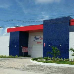 un edificio azul y rojo con una tienda de cocacola en Motel Flex Love (Adults Only), en Aracaju