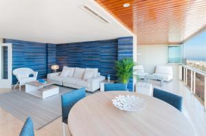 uma sala de estar com uma mesa e cadeiras azuis em Ag Bermudas Premium em Gandia
